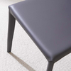 Minimalistisk blå sadelläderklädd armlös matstol med metallben